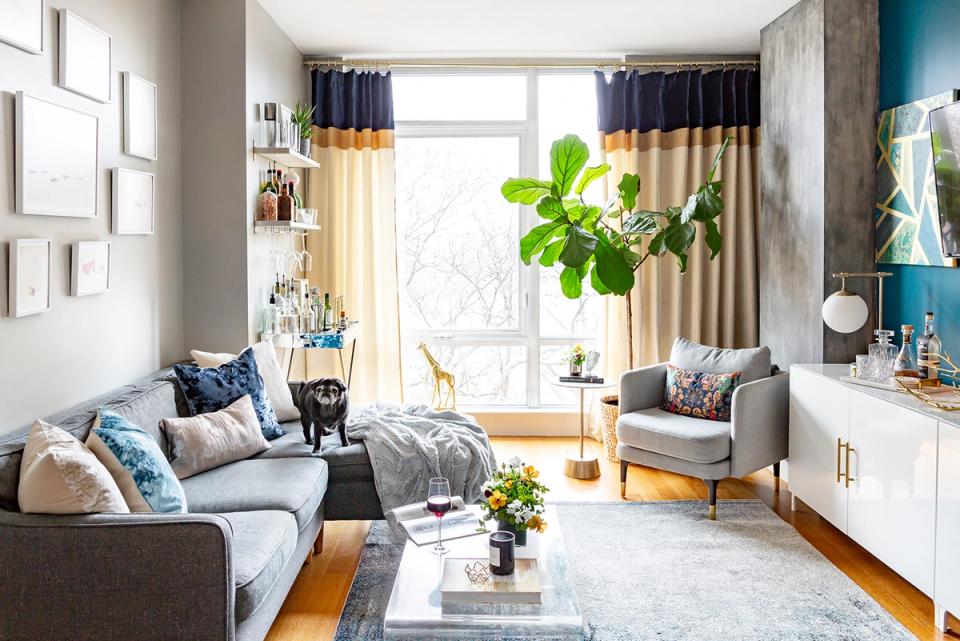 Bright Scandinavian-inspired living room with light gray seating, gold accents, and abundant natural light