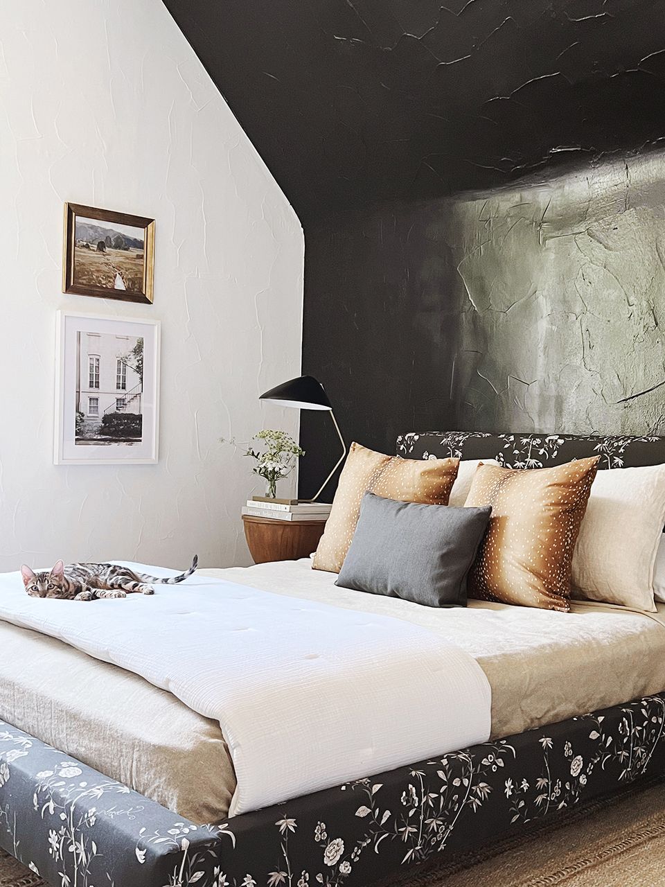 Modern bedroom with dramatic dark marble headboard and mixed metallic copper-gold pillows