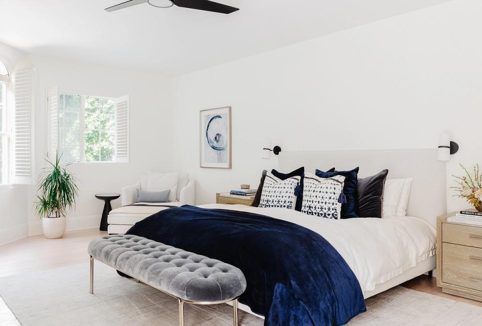 Minimalist bedroom with black ceiling fan and navy blue bedding