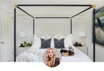Luxe hotel-inspired bedroom with black canopy bed, crisp white linens, zebra-print pillows, and brass accents