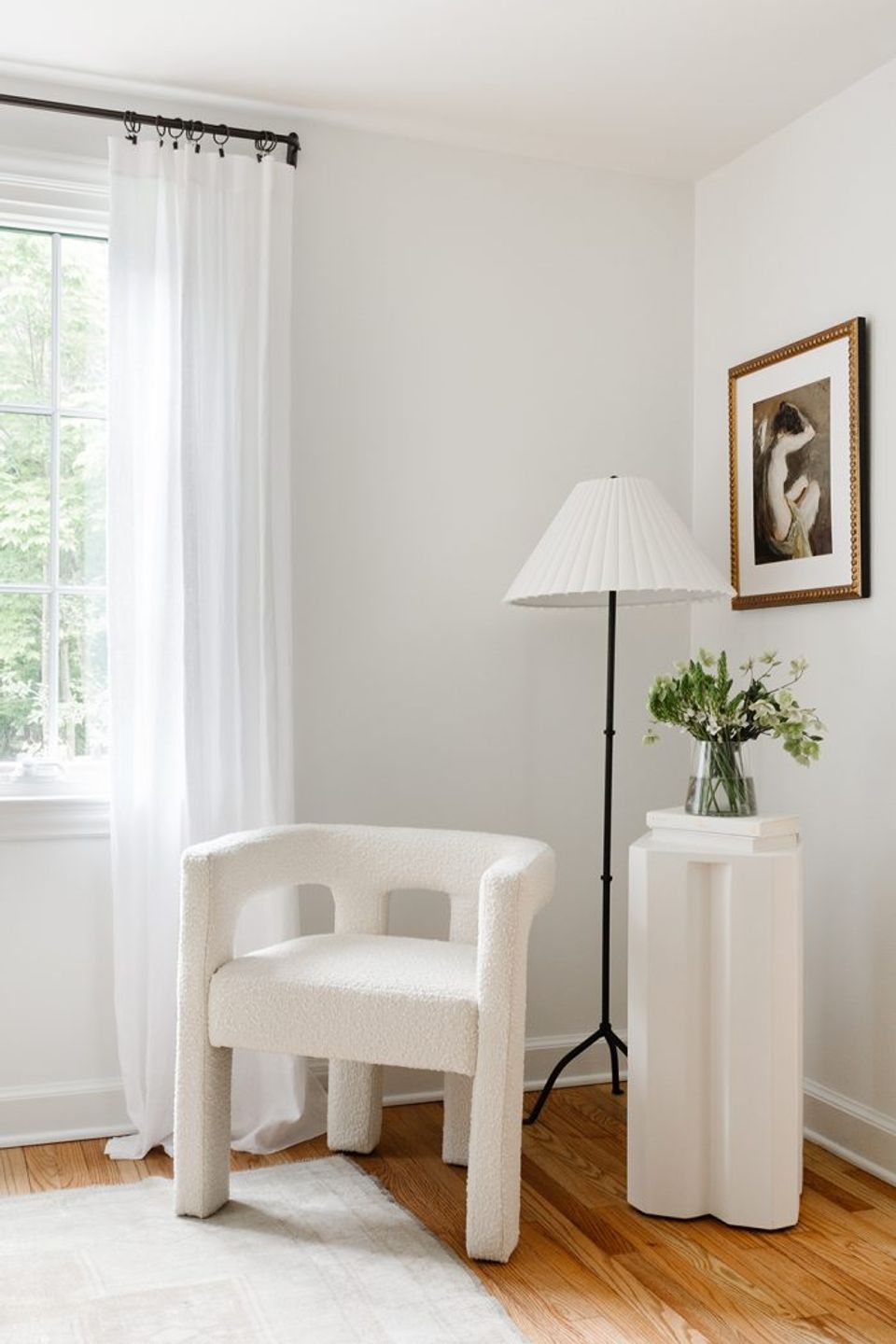 Tranquil contemporary corner with cream sculptural chair, floor lamp, and airy neutral color palette