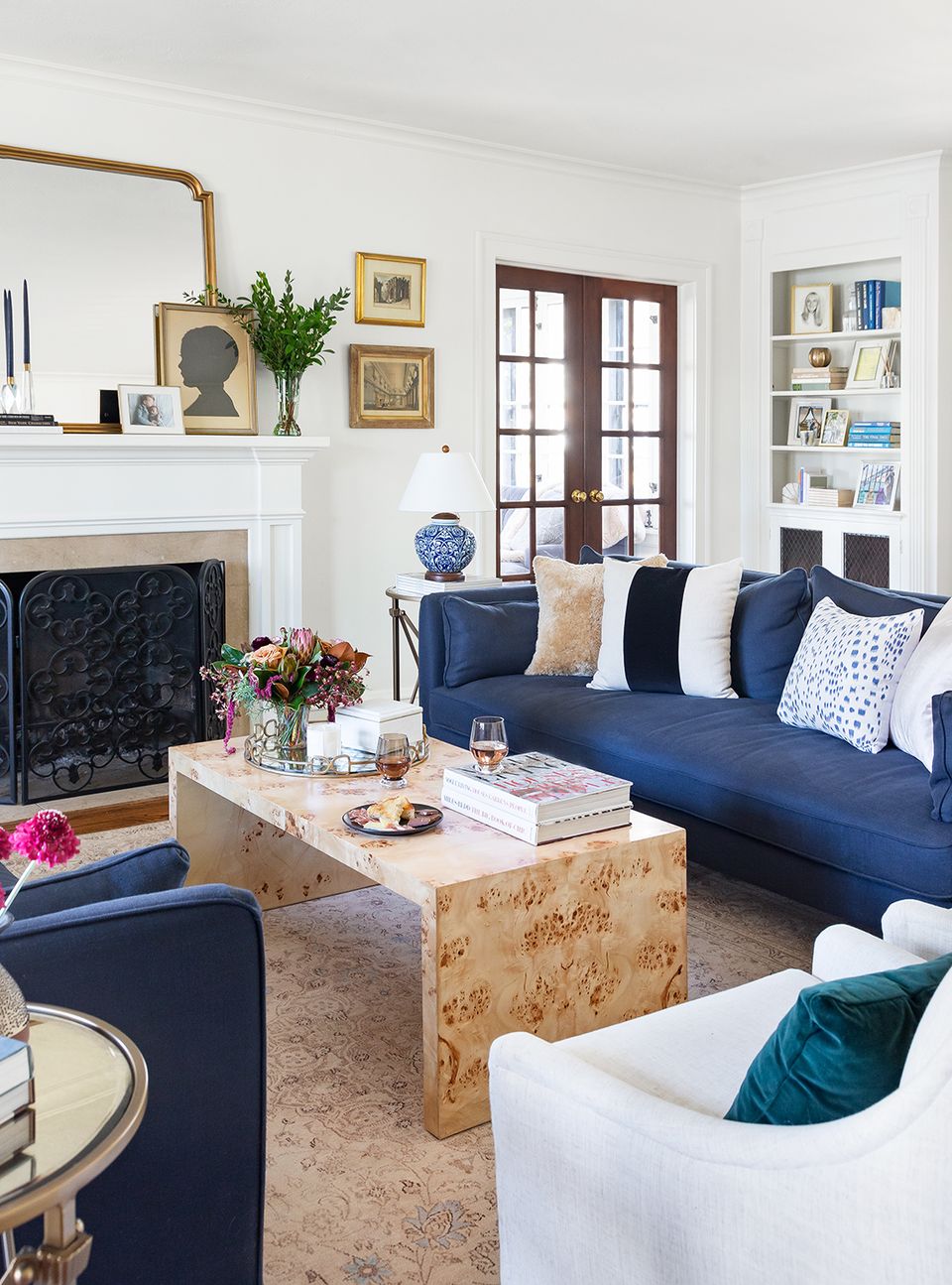 Classic living room with navy sofa, fireplace, gold accents, and timeless sophistication.