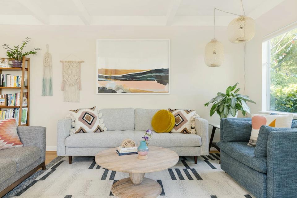 Bright, airy living room with warm white walls, gray seating, natural wood accents, and layered textures