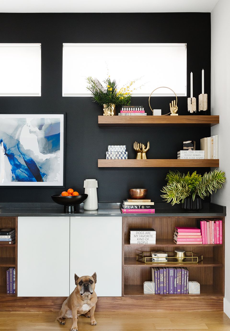 Modern living room with dark accent wall, natural wood floating shelves, and curated minimalist styling