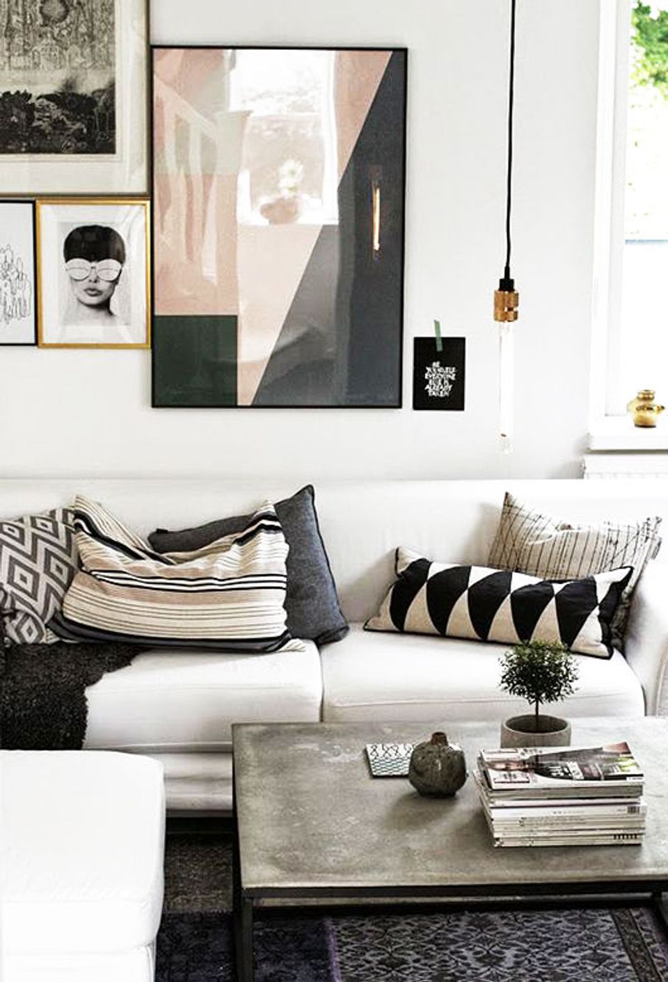 Minimalist living room with monochromatic black and white palette, geometric patterned pillows, and curated gallery wall art.