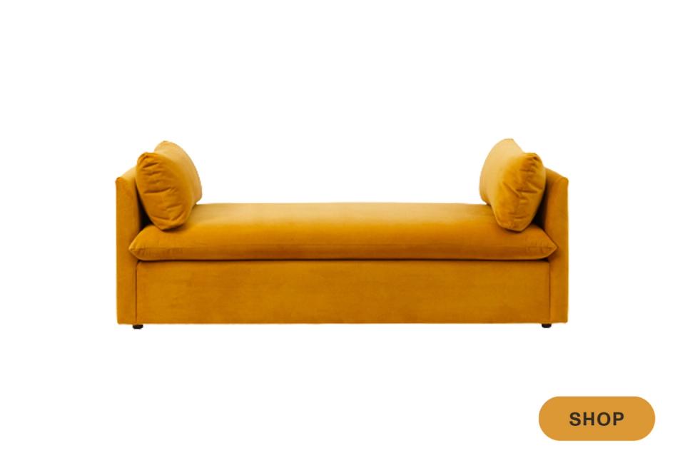 Bold mustard-gold velvet daybed with rolled bolster pillows and contemporary silhouette.