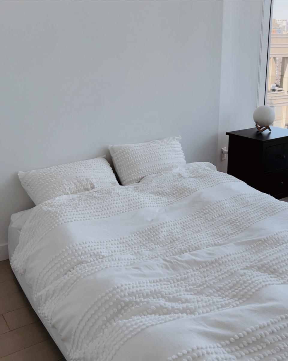 Calm Scandinavian bedroom with white textured linens and soft natural light
