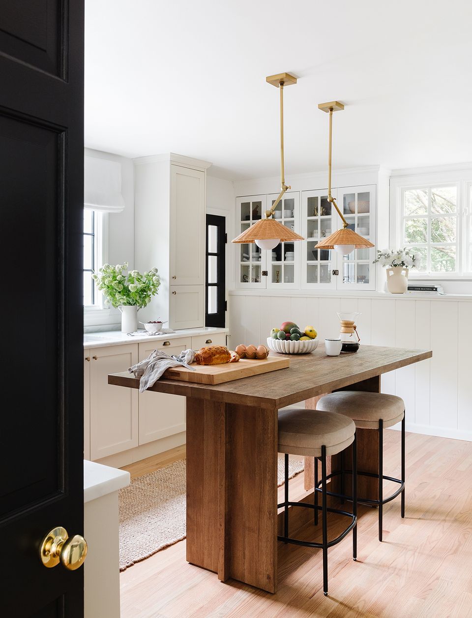 Contemporary kitchen with warm wood island, white cabinetry, brass accents, and clean lines blending beauty and practicality.