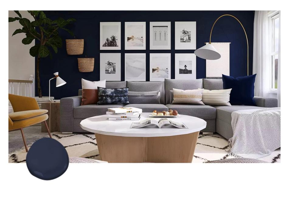 Modern living room with deep navy accent wall, gallery grid, curved brass floor lamp, warm wood coffee table, and mustard chair for contemporary sophistication
