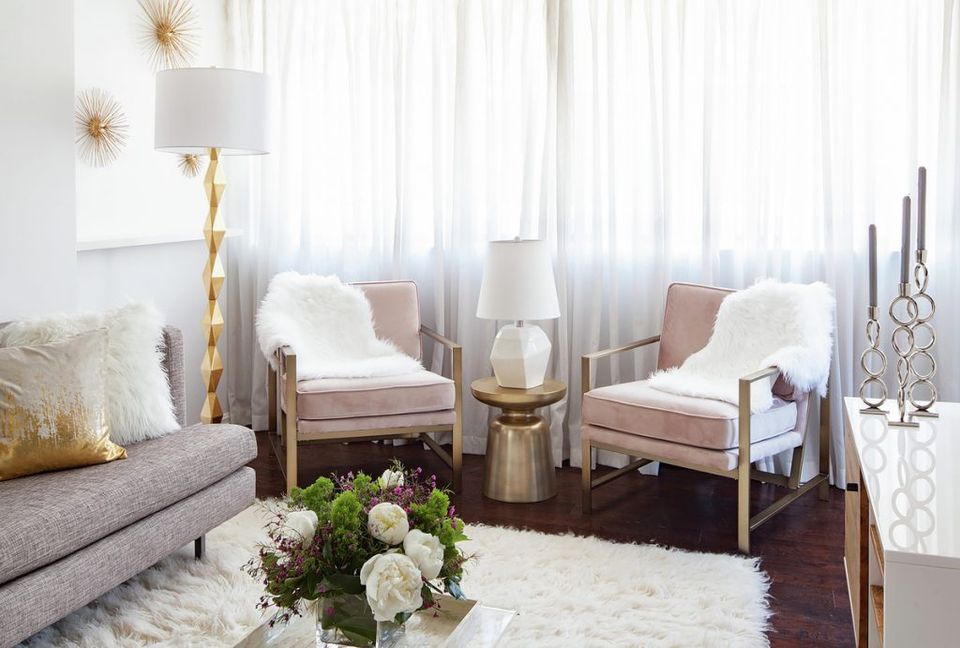Serene lounge with dusty rose chairs, gold accents, sheer white curtains, and natural greenery