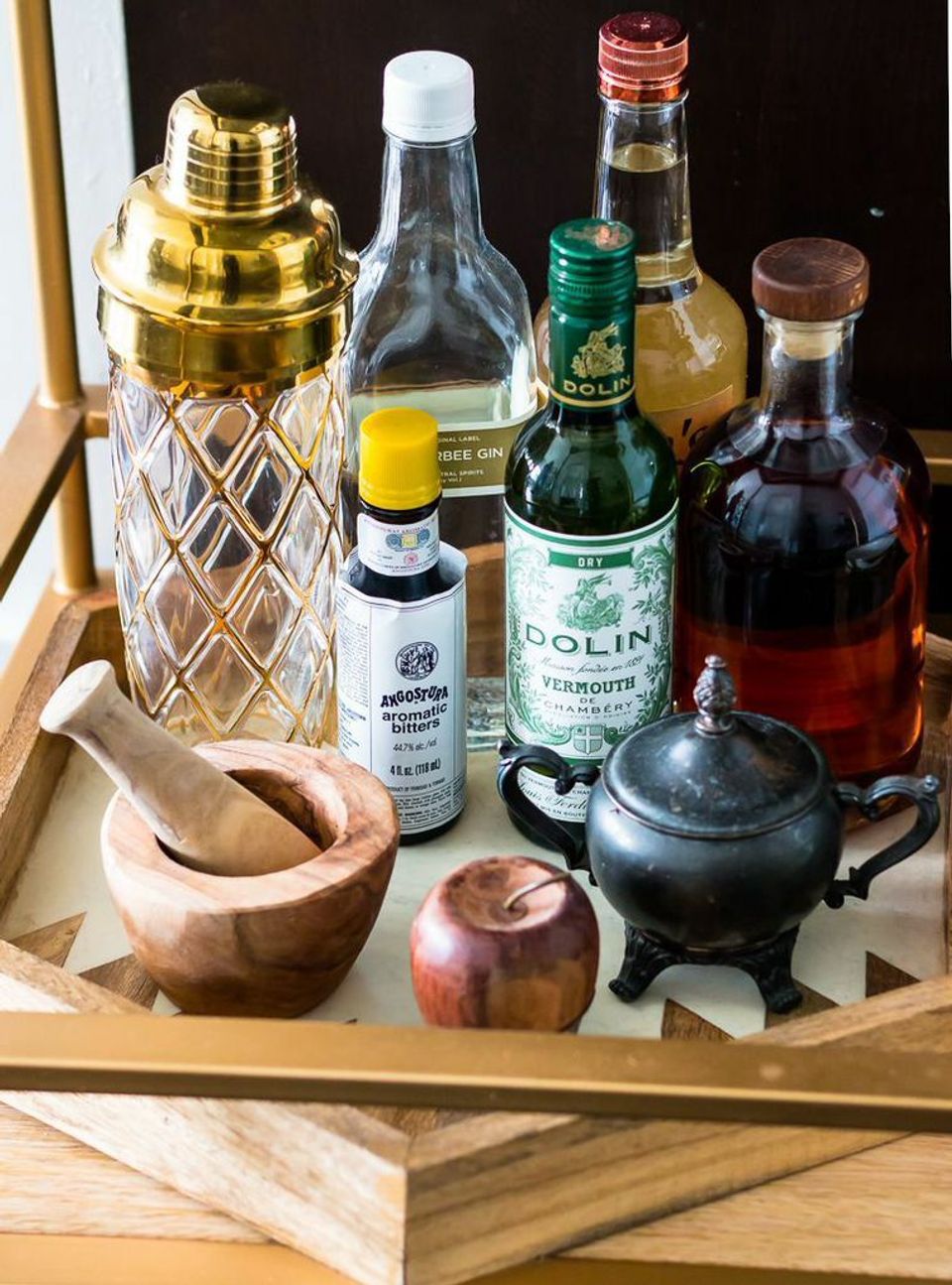 Sophisticated bar cart arrangement with vintage decanters, brass accents, and natural wood tones.