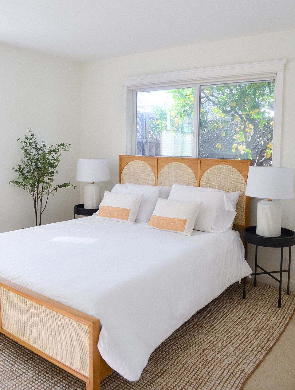 Bright mid-century modern bedroom with warm wood headboard, white linens, and natural wood accents