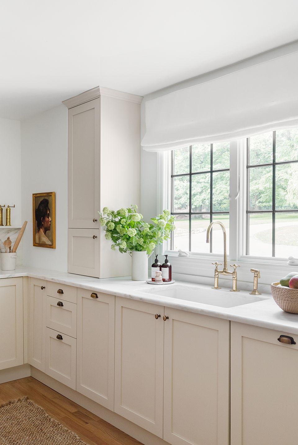Bright modern kitchen with creamy white cabinetry, black-trimmed windows, and airy aesthetic