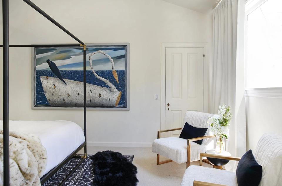Serene bedroom with large framed nautical diptych art above canopy bed in blue and white palette