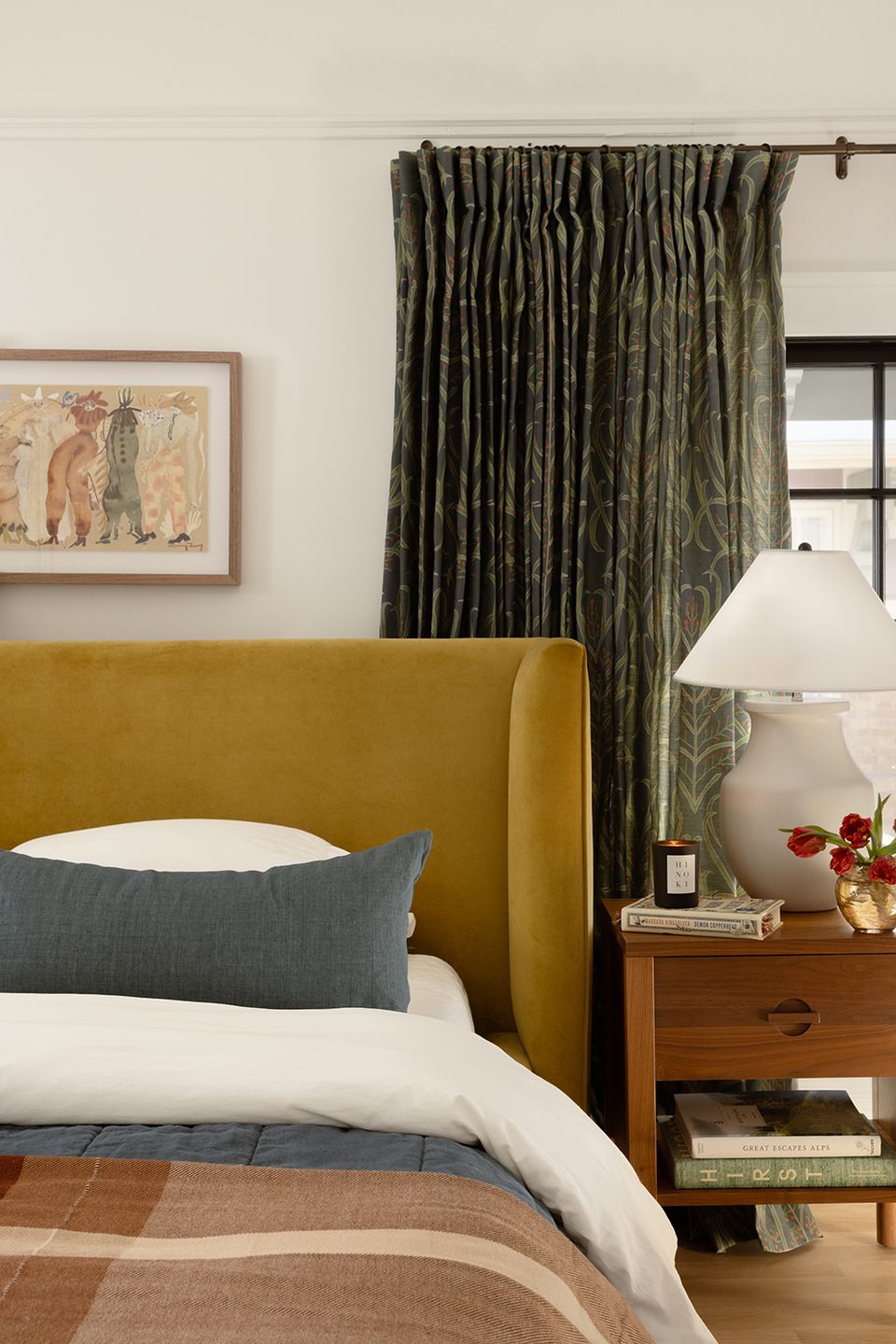 Curated gallery wall with mixed-frame artwork, pink tones, wooden railing, and collected vintage décor elements.