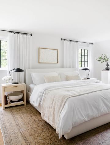 Serene modern bedroom with white linens, warm wood nightstands, and soft neutral color palette