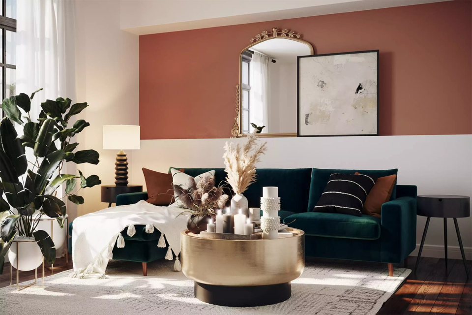 Warm living room with terracotta accent wall, deep green sofa, brass details, earthy contemporary elegance