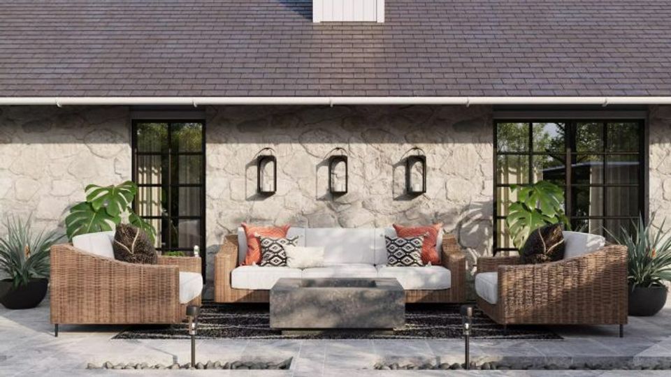 Contemporary courtyard with warm-toned wicker seating, geometric patterned pillows, and soft industrial modern aesthetic.