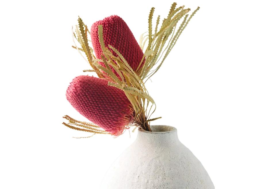 Modern coral and gold dried arrangement in sculptural white ceramic vessel