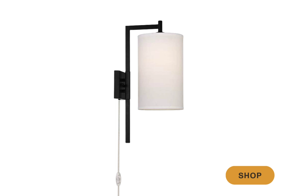 Sleek contemporary black sconce with cylindrical fabric shade and geometric architectural form