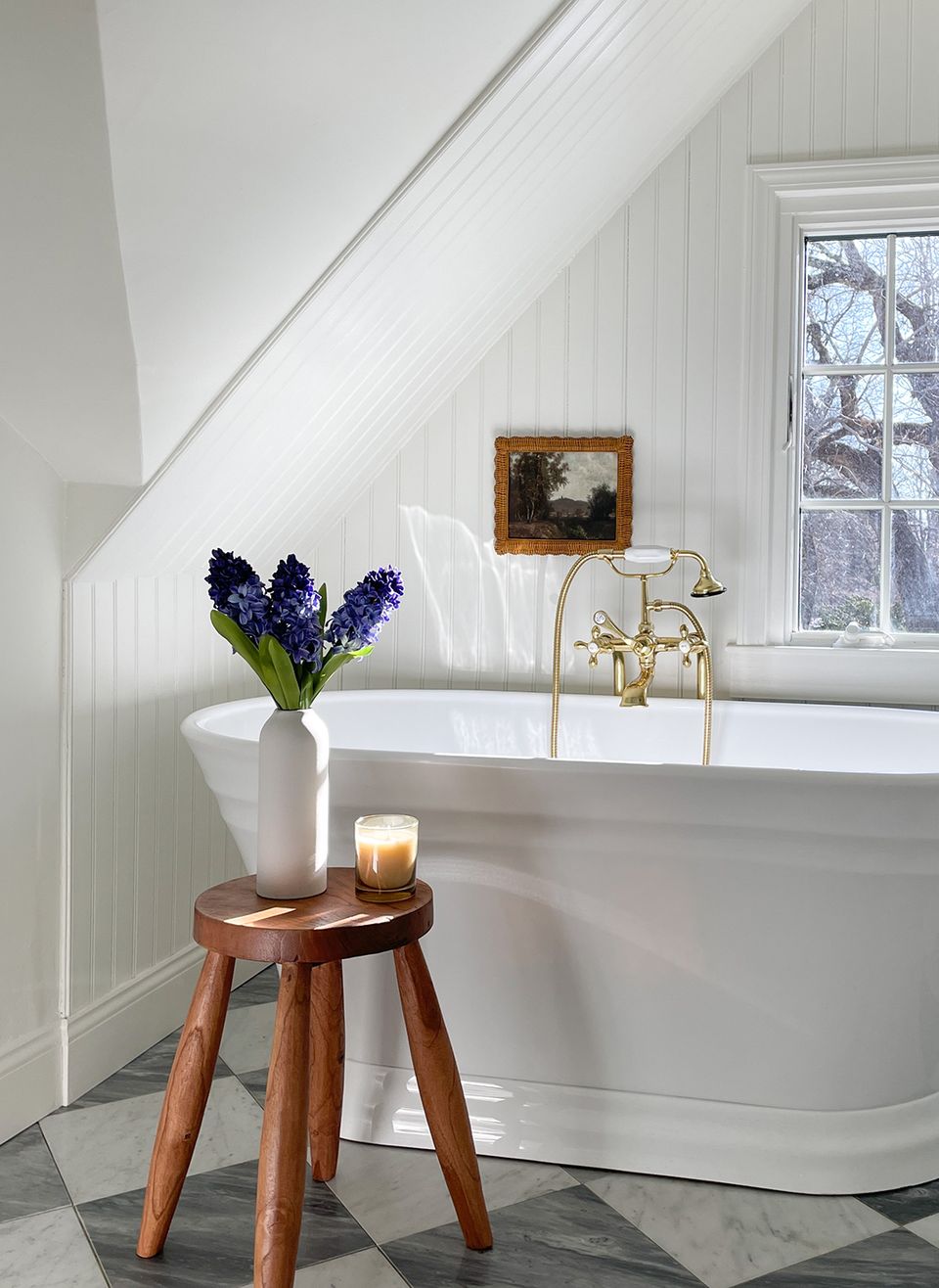 Serene spa-inspired bathroom with white shiplap, soaking tub, and warm wood stool
