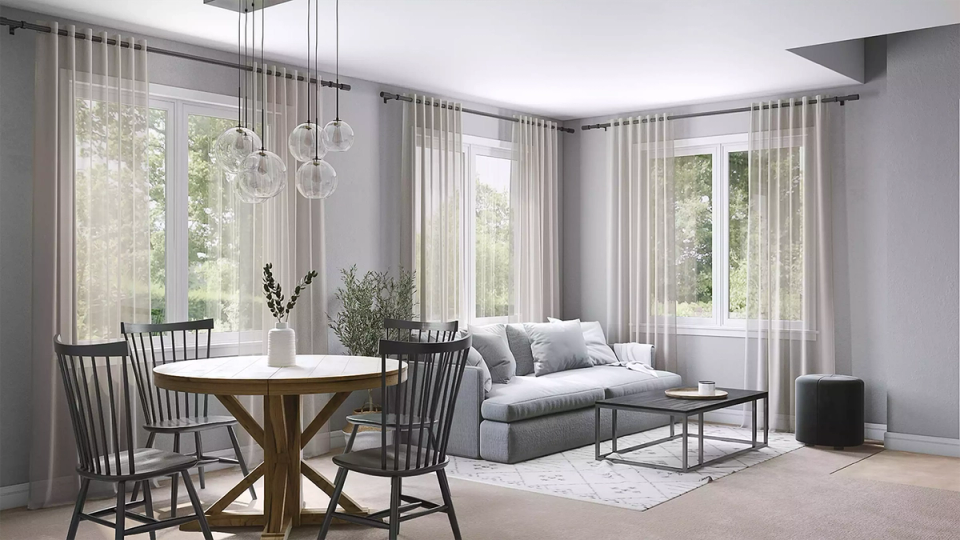 Scandinavian dining area with light wood table, Windsor chairs, and airy neutral palette with sheer curtains
