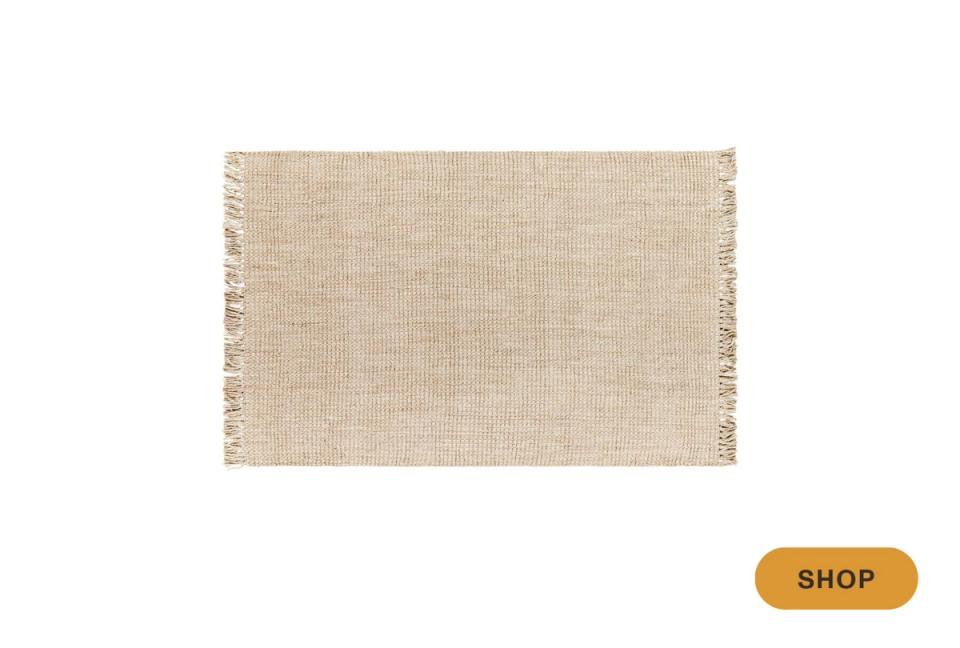 Natural linen area rug with fringe trim in warm cream textured weave