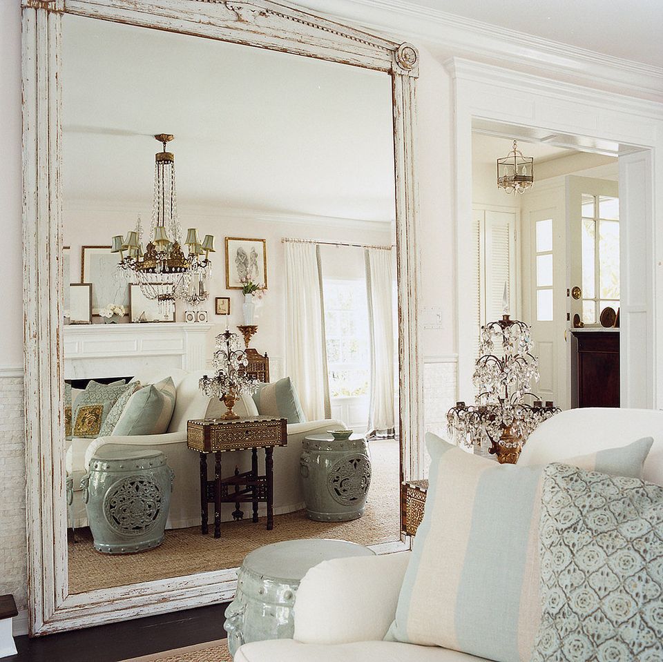 Vintage-inspired bedroom with ornate whitewashed mirror, soft sage accents, and romantic floral touches