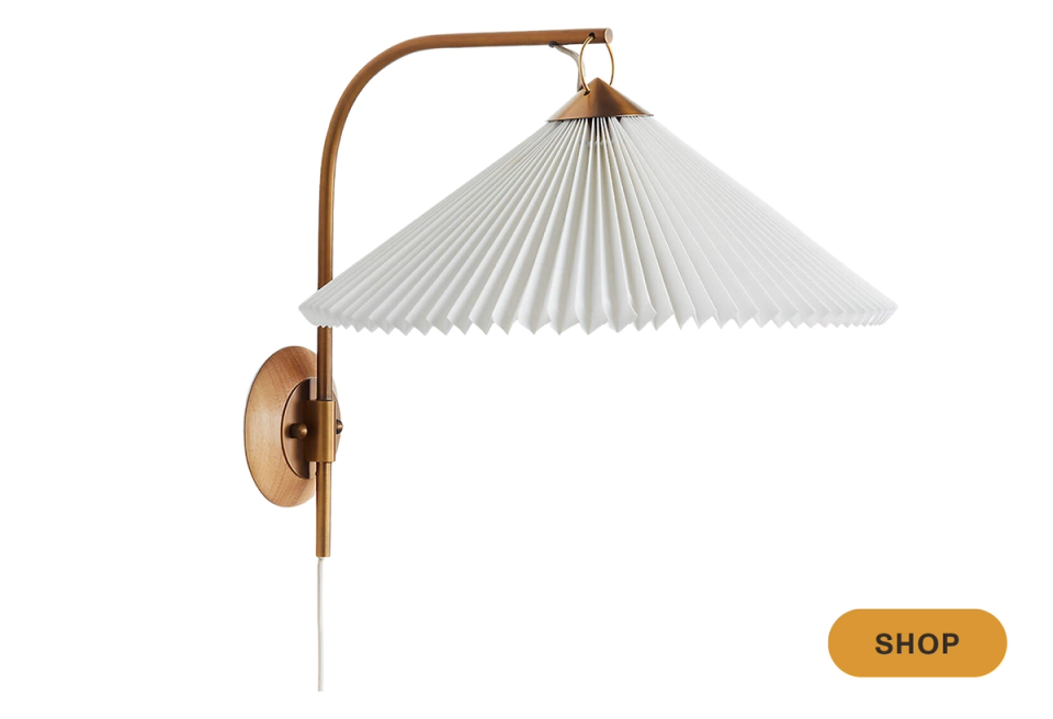 Japandi-inspired arc sconce combining natural wood, pleated white shade, and sculptural elegance