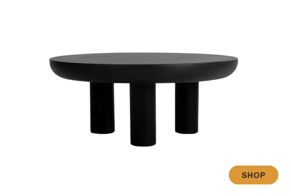 Contemporary black round table with sculptural cylindrical legs