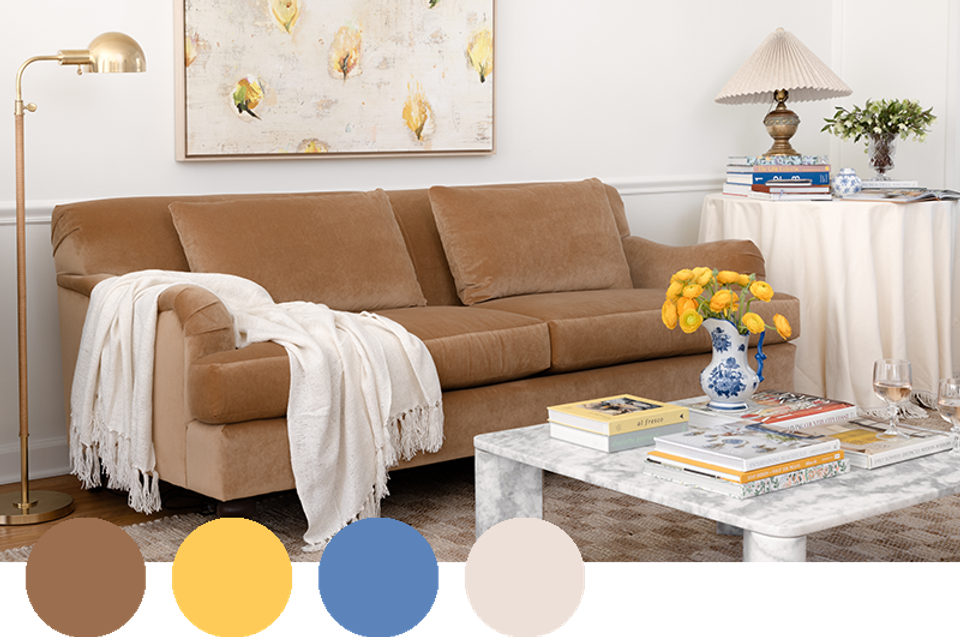 Eclectic living room mixing caramel leather, golden botanical art, and soft blue accents.