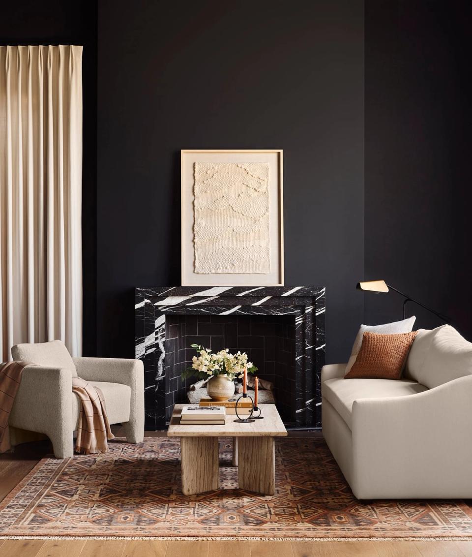 Minimalist living room contrasting black walls with cream upholstered seating and warm wood base