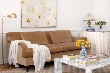 Mid-century modern living room with tan leather sofa and gold-leaf abstract artwork