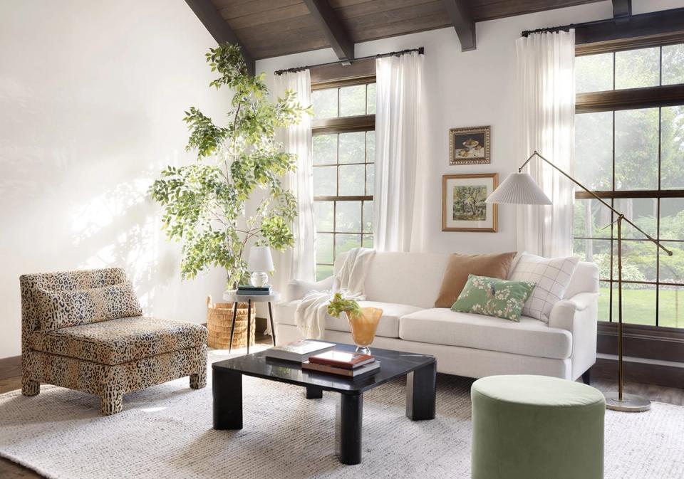 Bright, airy living room with organic modern style: cream sofa, natural wood accents, living plants, and soft neutral palette create serene coastal-inspired space