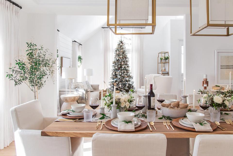 Scandinavian-inspired minimalist holiday setting with white decor, natural wood, and fresh greenery