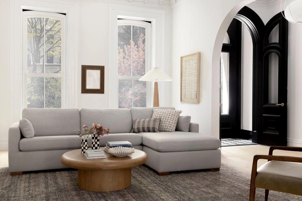 Bright, airy living room with gray sofa, black architectural doors, and warm wood accents for contemporary contrast