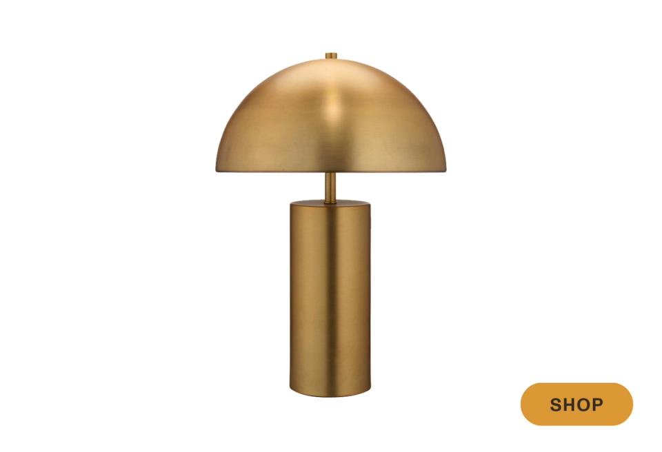 Sculptural brass table lamp with dome shade and cylindrical base, contemporary elegance