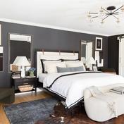 Contemporary bedroom with moody dark gray walls, white bedding, and mid-century modern furnishings creating sophisticated contrast
