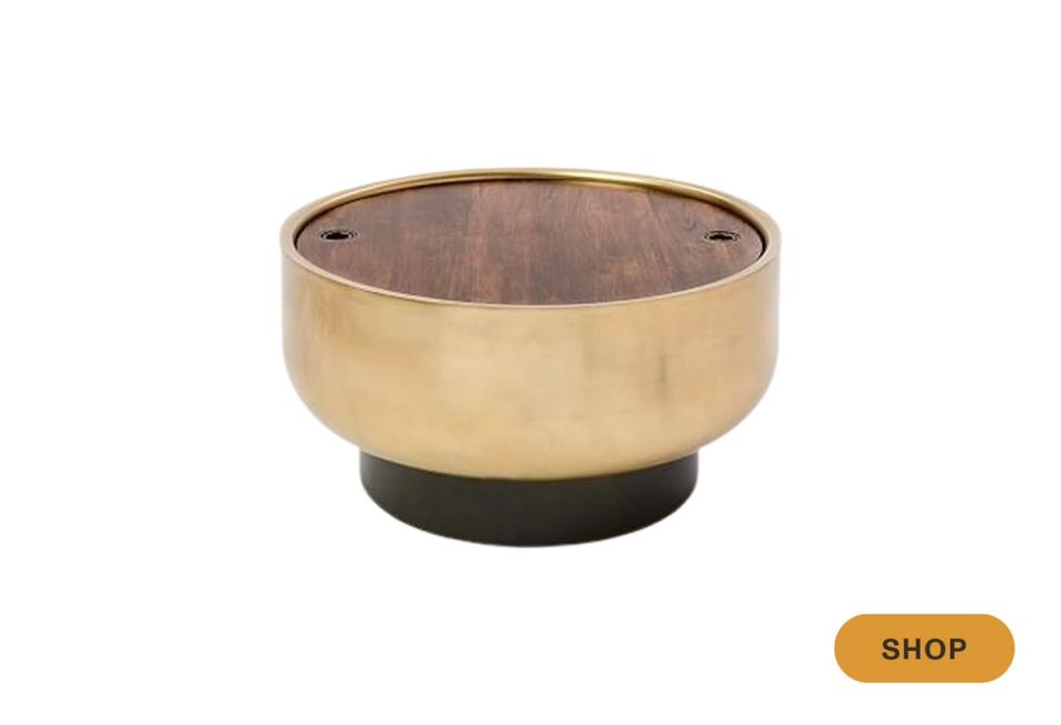 Modern brass bowl with black base, contemporary hidden storage accent