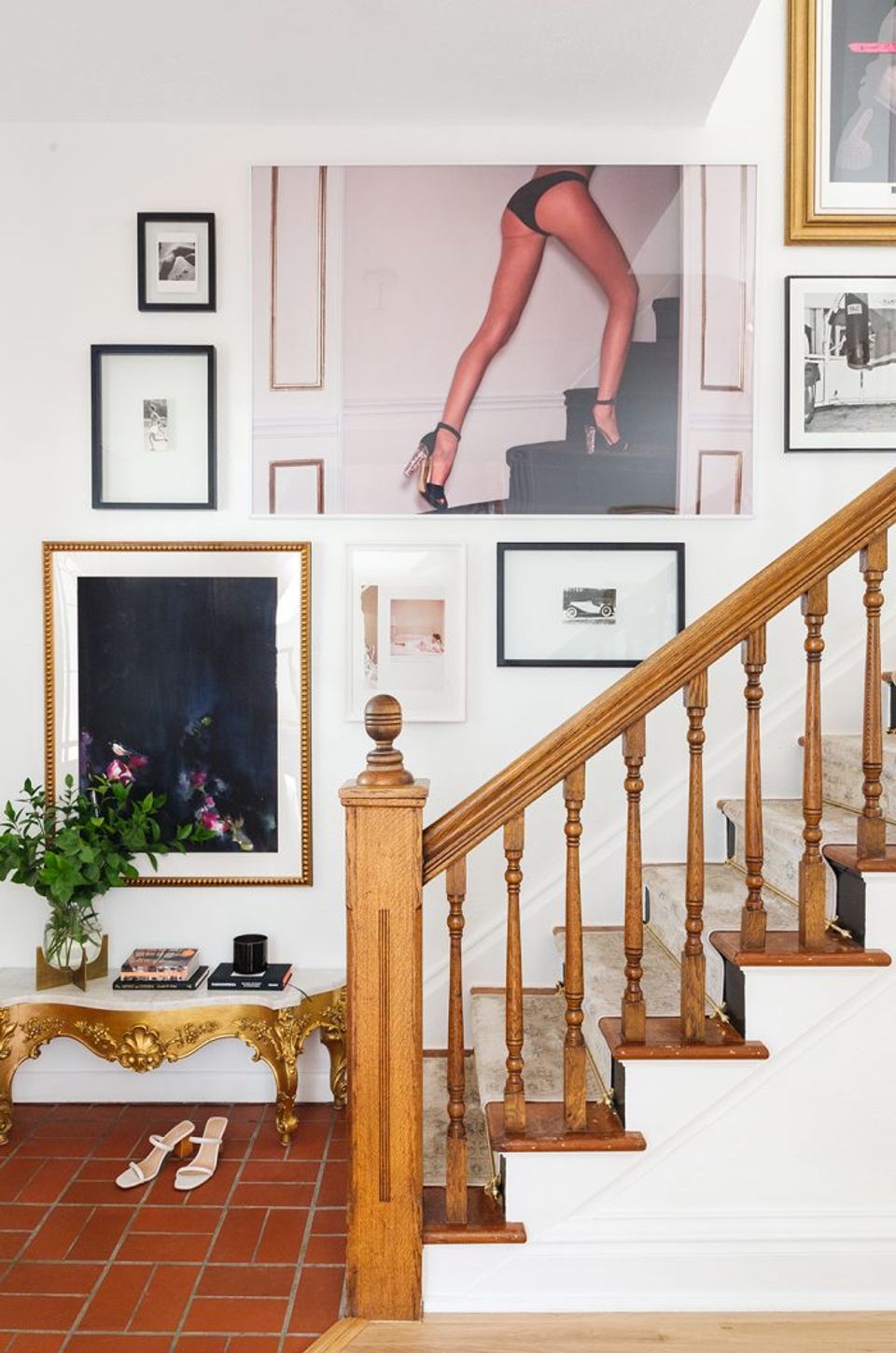 Eclectic gallery wall with mixed frames, gold accents, and vintage charm on staircase