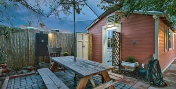 Rustic mid-century patio with warm wood tones, terracotta accents, and industrial elements