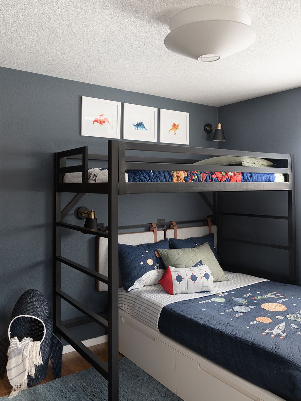 Contemporary kids' bedroom with slate blue walls, black metal loft bed, and playful navy bedding