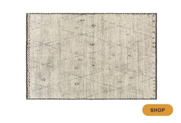 Understated botanical area rug in soft gray and cream with delicate scattered motifs