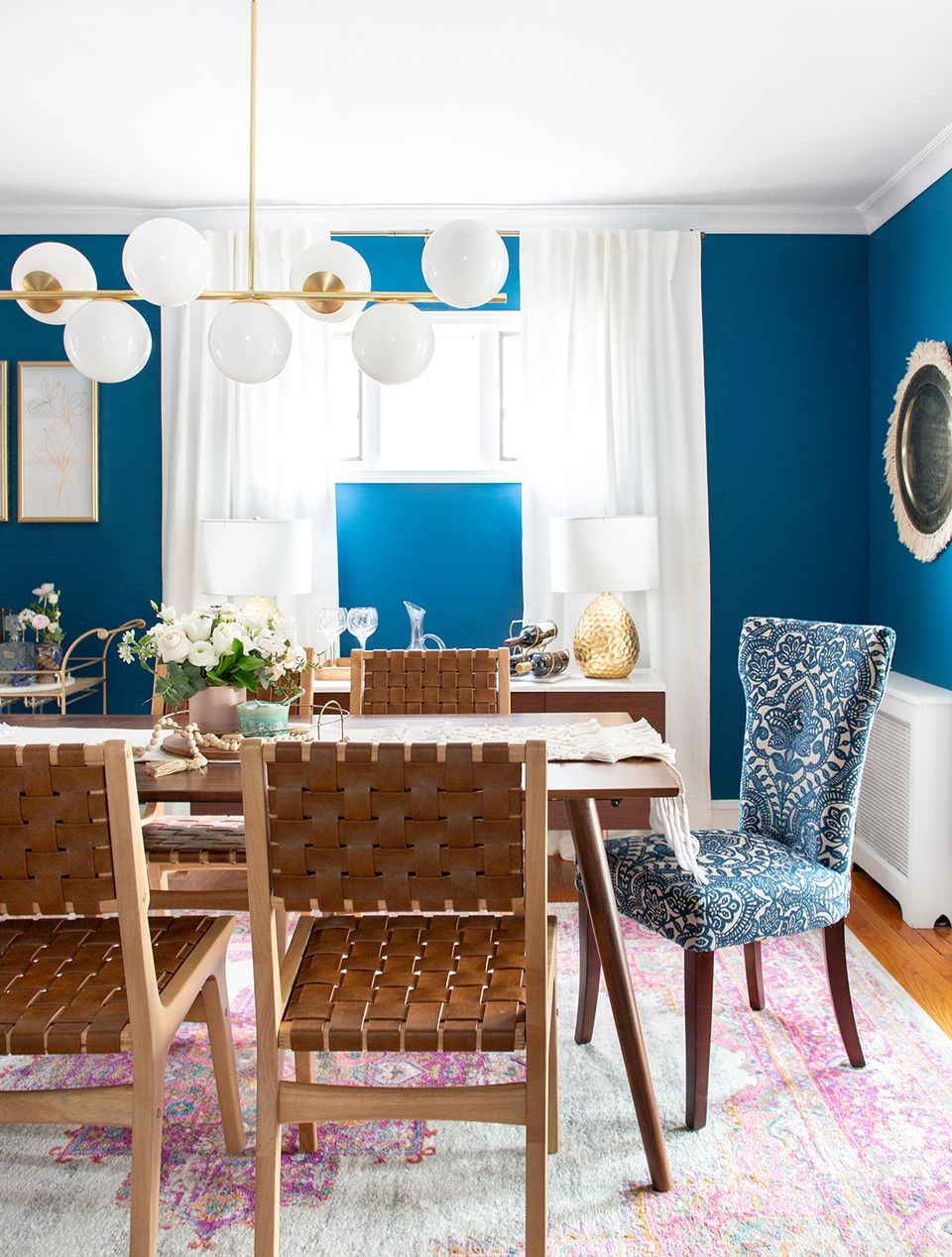Contemporary bold design with jewel-tone blue walls and geometric accent chairs