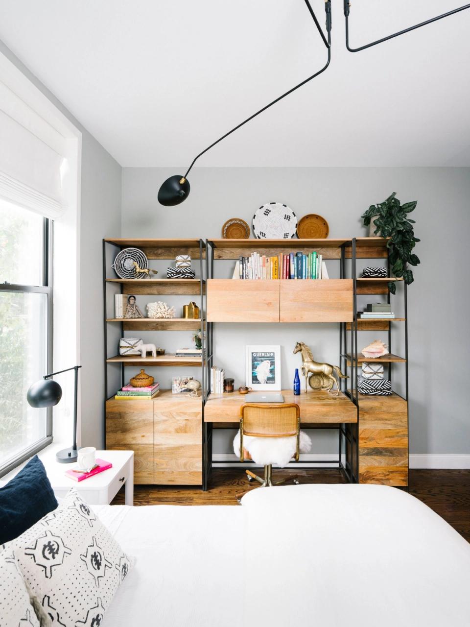 Scandinavian bedroom with warm wood modular shelving, minimalist black pendant lights, and serene neutral tones