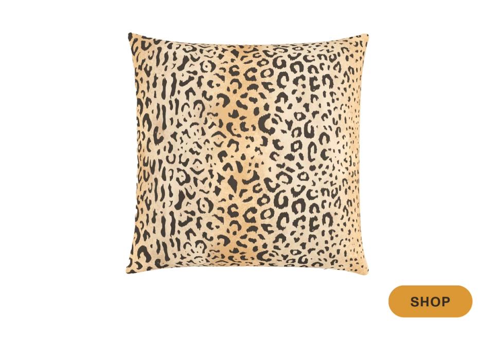 Bold statement pillow with warm leopard print pattern on natural linen background