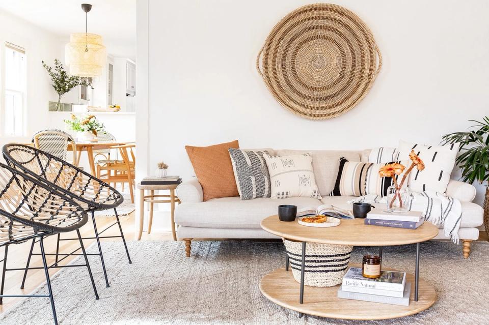 Scandinavian living room with warm wood tones, natural fiber accents, woven wall art, and neutral upholstery creating an airy, organic aesthetic