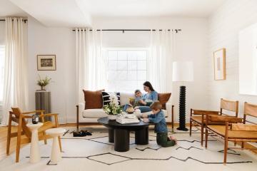 Bright Scandinavian living room with warm wood furniture, neutral palette, and natural light from large windows
