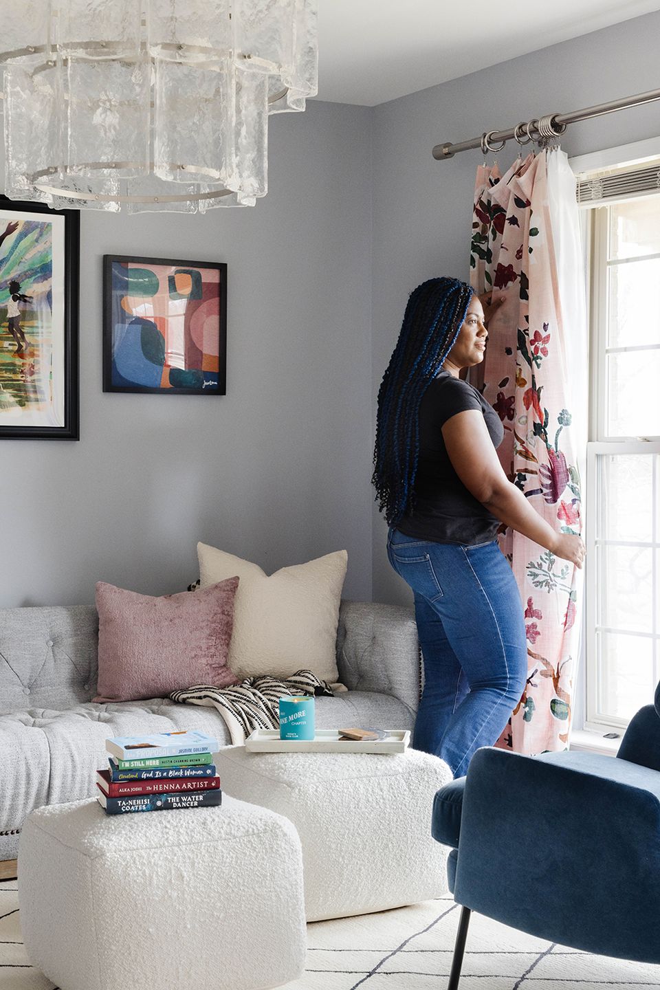 Bright reading corner with floral curtains, stacked books, and relaxing neutral palette with blue accents
