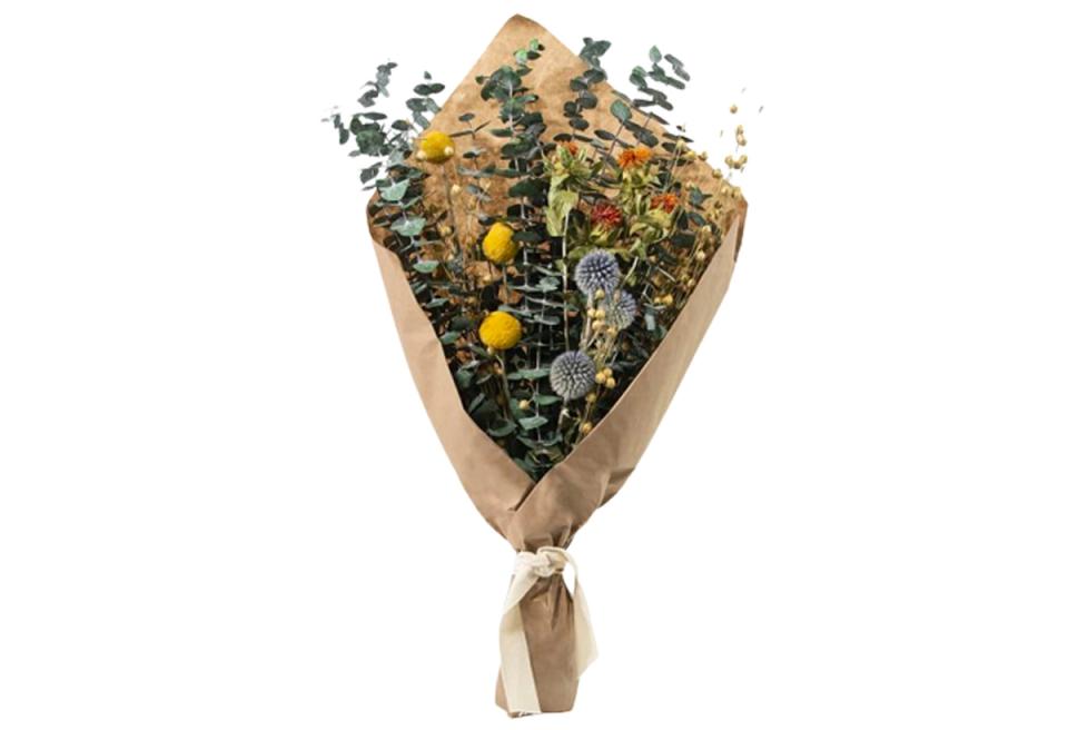 Organic botanical bouquet with mustard accents wrapped in kraft paper
